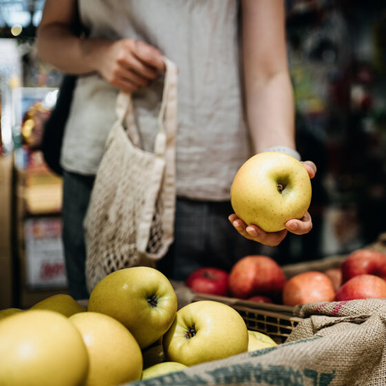 femme dans un magasin, prenant une pomme